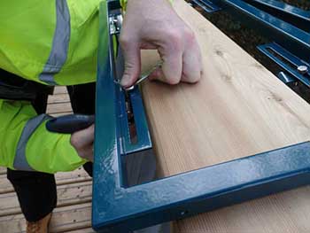 Metal frames for graphics panels being clamped to the handrail