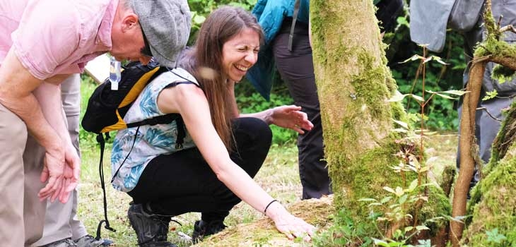 People exploring the trees at Westonbirt through touch, smell and sound