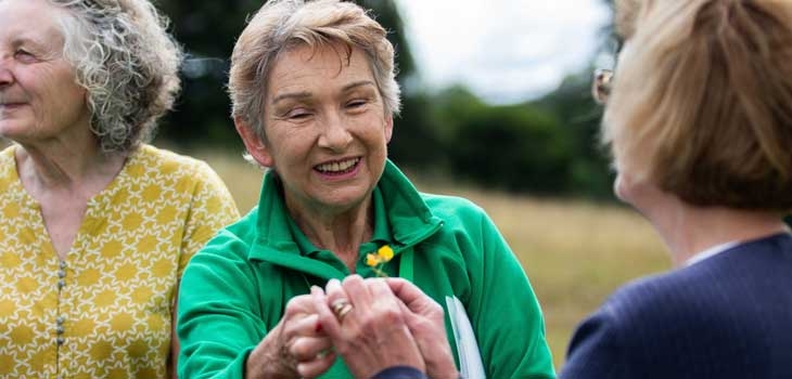 Volunteer guide showing visitors wildflowers