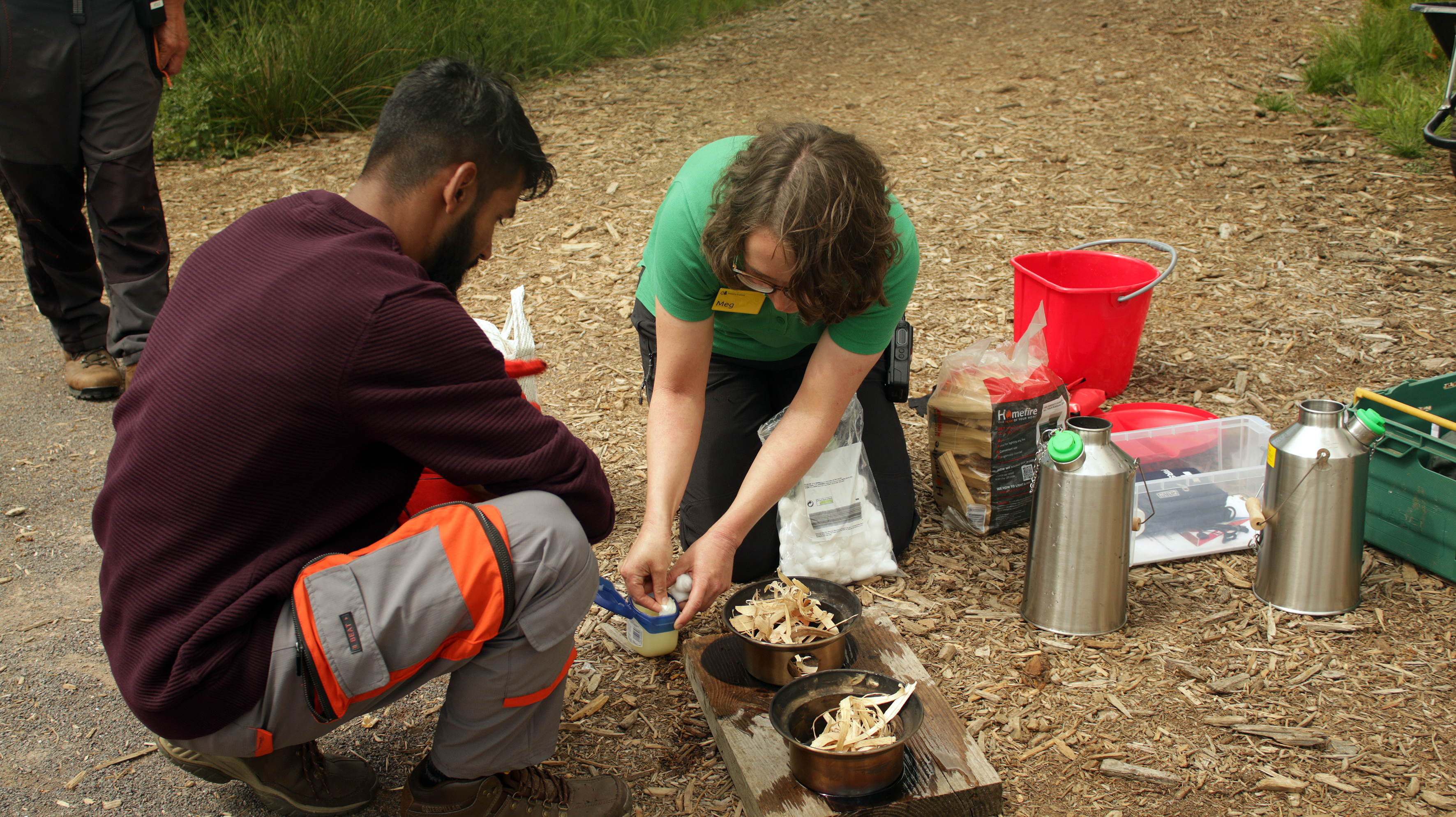 two people Safely building firepit